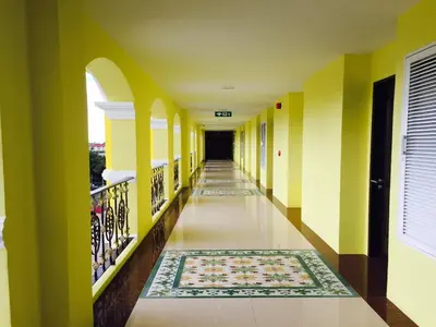 a hallway with yellow and white walls and a rug at Phuket Chinoinn-SHAPlus Certified in Phuket Town