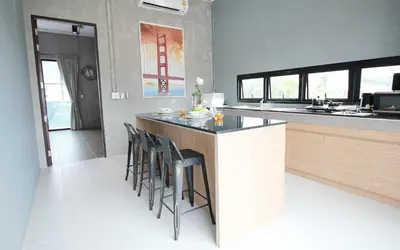 a kitchen with a counter and stools in a kitchen at Unique Loft Apartment in Kamala Beach