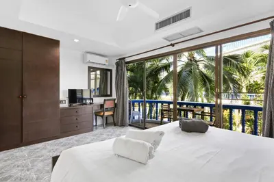 a bedroom with a large white bed and a balcony at The Club Residence Kamala Beach in Kamala Beach