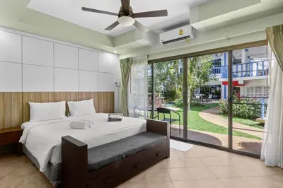 a bedroom with a large bed and a large window at The Club Residence Kamala Beach in Kamala Beach