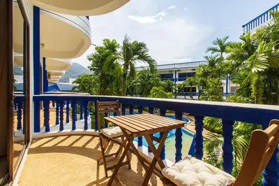 a balcony with a table and chairs and a pool at The Club Residence Kamala Beach in Kamala Beach