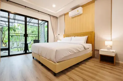 a bedroom with a bed and a large window at T House in Bang Tao Beach