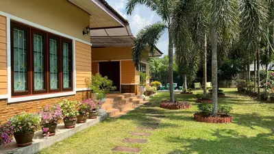 a house with potted plants on the side of it at Malinee Villa Phuket in Bang Tao Beach