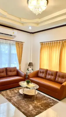 a living room with two brown leather couches and a table at Malinee Villa Phuket in Bang Tao Beach