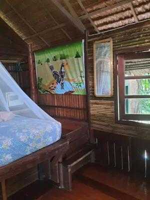 a wooden cabin with a bed and a window at Sabai Corner Bungalows - SHA Extra Plus in Ko Yao Noi