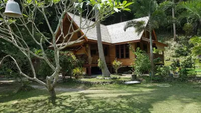 a small wooden house in the middle of a yard at Sabai Corner Bungalows - SHA Extra Plus in Ko Yao Noi