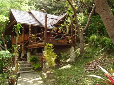 a small house with a porch and stairs in a garden at Sabai Corner Bungalows - SHA Extra Plus in Ko Yao Noi