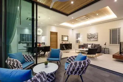 a living room with blue chairs and a couch at Inspire Villas Phuket in Rawai Beach
