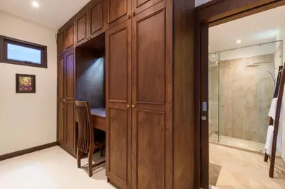 a bathroom with wooden cabinets and a walk in shower at Inspire Villas Phuket in Rawai Beach