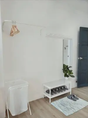 a white room with a blue door and a rug at Thira House in Karon Beach