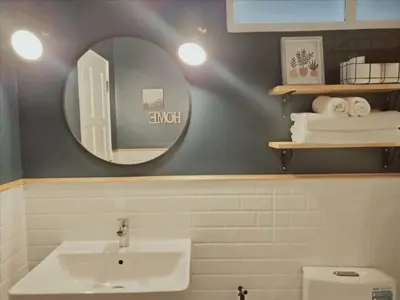 a bathroom with a sink and a mirror at Thira House in Karon Beach