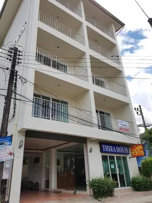 a large white building with a balcony at Thira House in Karon Beach