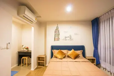 a bedroom with a blue bed with gold pillows at Centrio nearby Central Phuket in Phuket Town