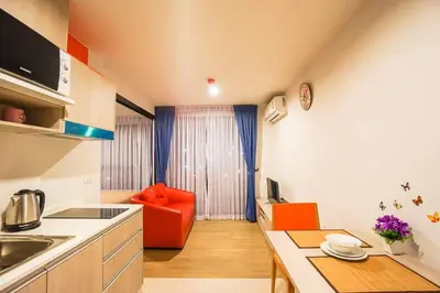 a small kitchen with an orange couch in a room at Centrio nearby Central Phuket in Phuket Town