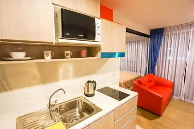 a small kitchen with a sink and a red chair at Centrio nearby Central Phuket in Phuket Town