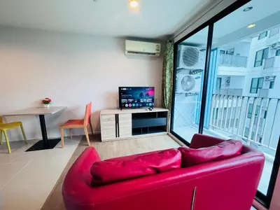 a living room with a red couch and a tv at Centrio nearby Central Phuket in Phuket Town