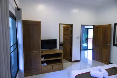 a living room with a television and a tv stand at Chanapha Residence in Tab Kaek Beach
