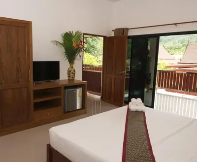 a bedroom with a bed and a tv and a tv at Chanapha Residence in Tab Kaek Beach