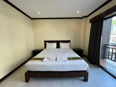 a bedroom with a bed and a large window at Baan Kingkeaw Thamdee Patong in Patong Beach