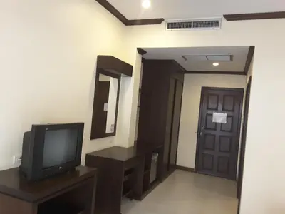 a living room with a television and a door at Baan Kingkeaw Thamdee Patong in Patong Beach