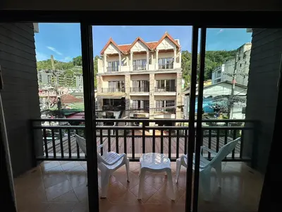 a balcony with a view of a building at Baan Kingkeaw Thamdee Patong in Patong Beach