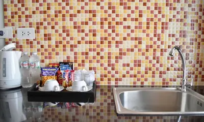 a kitchen counter with a sink next to a sink at Isayarada Apartment in Thalang