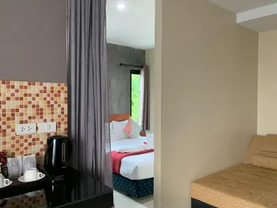 a hotel room with a bed and a mirror at Isayarada Apartment in Thalang