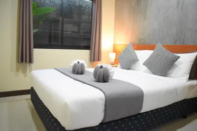 a bedroom with a large bed with two stuffed animals on it at Isayarada Apartment in Thalang