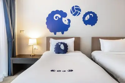 a bedroom with two beds with blue sheep stickers on the wall at Kokotel Phuket Patong in Patong Beach