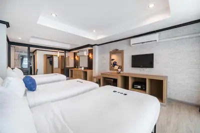 a hotel room with two beds and a flat screen tv at Kokotel Phuket Patong in Patong Beach