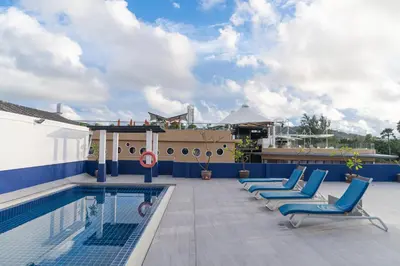 a row of blue lounge chairs next to a swimming pool at Kokotel Phuket Patong in Patong Beach