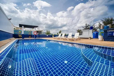 a large swimming pool with chairs at Kokotel Phuket Patong in Patong Beach