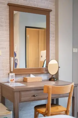 a wooden desk with a mirror and a wooden chair at Kokotel Krabi Ao Nang in Ao Nang Beach