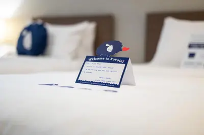 a sign sitting on top of a bed at Kokotel Krabi Ao Nang in Ao Nang Beach