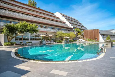 a large swimming pool in front of a building at Orchidacea Resort - Kata Beach in Kata Beach