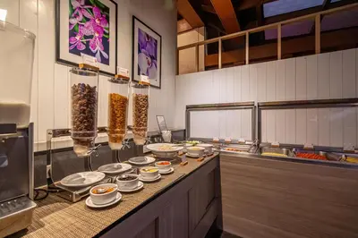 a kitchen with plates and bowls of food on a counter at Orchidacea Resort - Kata Beach in Kata Beach