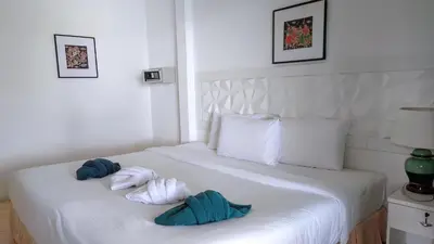 a bedroom with two towels on a white bed at On The Hill Karon Resort in Karon Beach