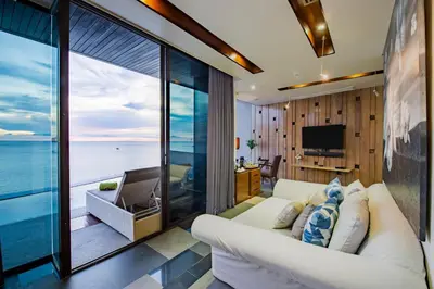 a living room with a white couch and a view of the ocean at Impiana Private Villas Kata Noi in Kata Beach