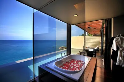 a bathroom with a tub with a view of the ocean at Impiana Private Villas Kata Noi in Kata Beach
