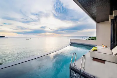 a swimming pool with a view of the ocean at Impiana Private Villas Kata Noi in Kata Beach