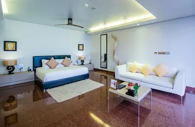 a room with a bed and a couch and a table at Impiana Private Villas Kata Noi in Kata Beach