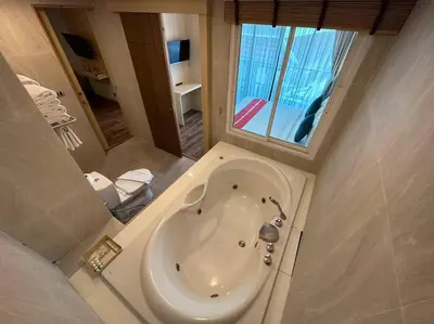 a bathroom with a bath tub and a sink at Baan Yuree Resort & Spa - SHA Plus in Patong Beach