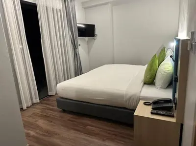 a bedroom with a bed and a desk with a computer at Baan Yuree Resort & Spa - SHA Plus in Patong Beach