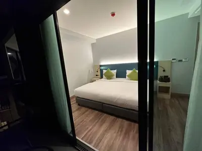 a bedroom with a bed with yellow pillows at Baan Yuree Resort & Spa - SHA Plus in Patong Beach