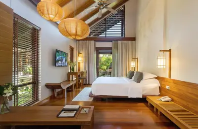 a bedroom with a bed and a table at The Tubkaak Krabi Boutique Resort in Tab Kaek Beach