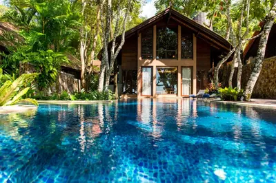 a swimming pool in front of a house at The Tubkaak Krabi Boutique Resort in Tab Kaek Beach