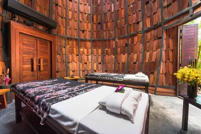 a bedroom with two beds in a wooden wall at The Tubkaak Krabi Boutique Resort in Tab Kaek Beach