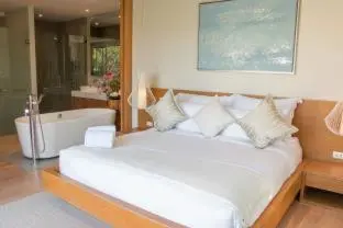 a bedroom with a white bed and a bath tub at Trichada Villas by RESAVA in Bang Tao Beach