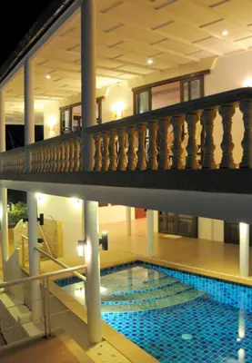 a large swimming pool in a building with a staircase at Surin villa in Surin Beach