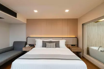 a bedroom with a large bed and a bath tub at Phuket Graceland Resort and Spa in Patong Beach